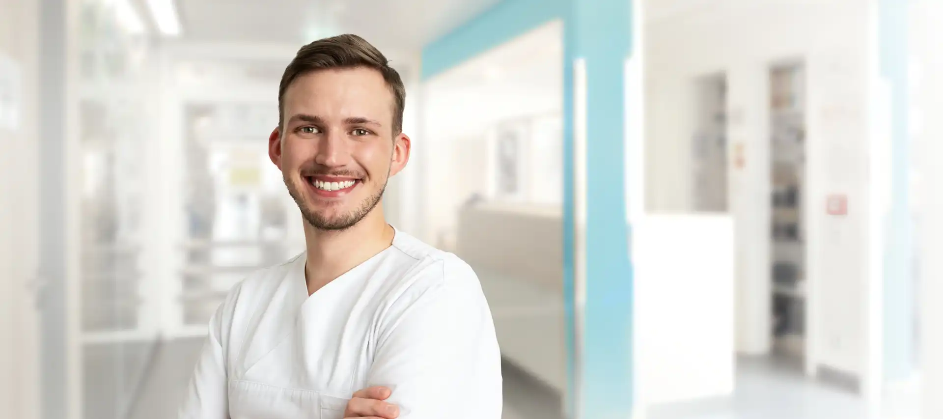 Ein Pfleger in weißer Arbeitskleidung