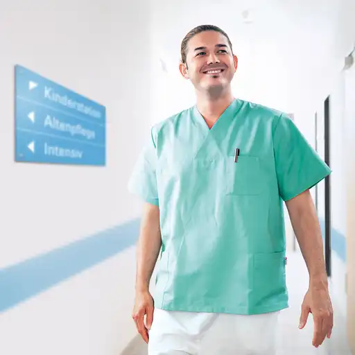 Ein Pfleger in einem Krankenhausflur